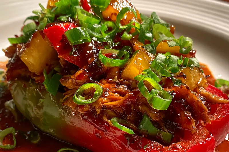 Vegetables being stir-fried in a hot wok with glossy sauce coating the colorful mixture