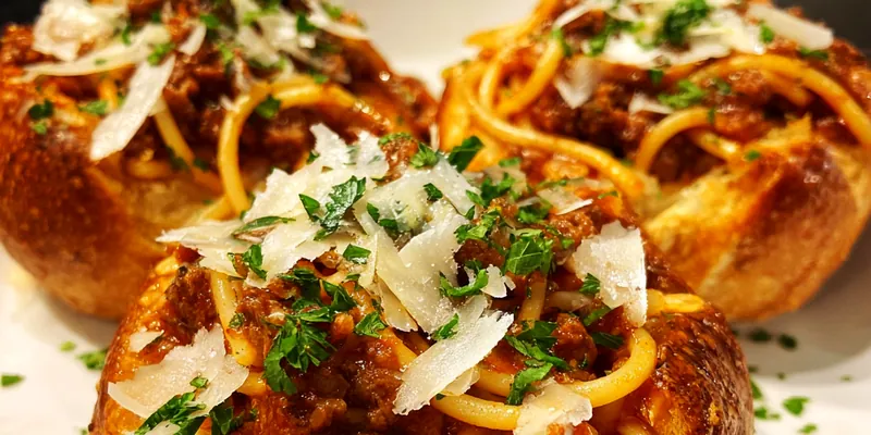 Delicious Cheesy Spaghetti Bread Bowls served on a plate