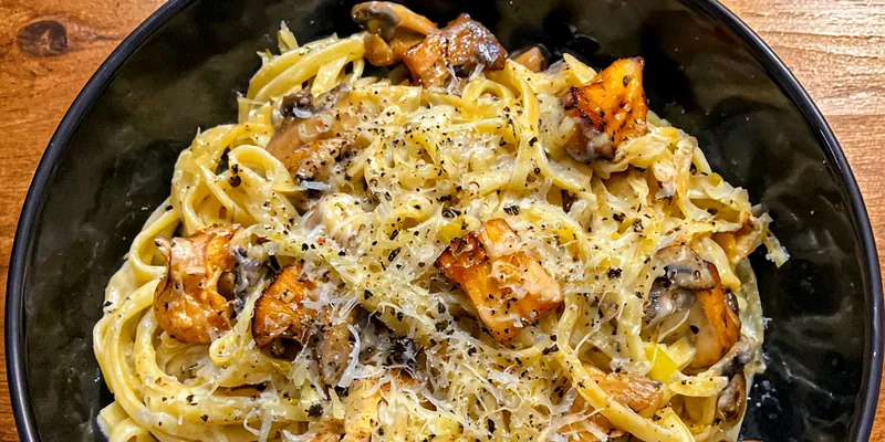 A vibrant plate of Mushroom Gruyere Pasta topped with fresh parsley and Parmesan cheese.