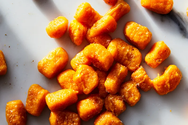 Fresh ingredients for savory butternut squash gnocchi including squash, flour, and greens.