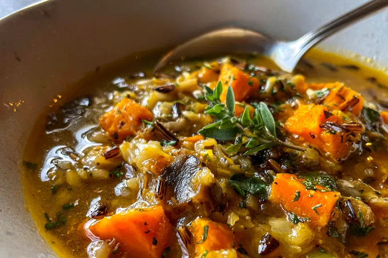 Cooking Vegan Pumpkin Wild Rice Soup in a pot on the stove.